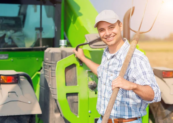 Agricultor sorrindo segurando forquilha — Fotografia de Stock