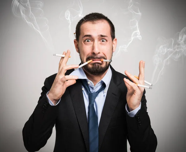 Nervous man smoking a lot of cigarettes — Stock Photo, Image