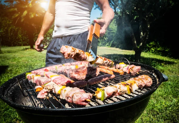 Homem preparando carne na grelha — Fotografia de Stock