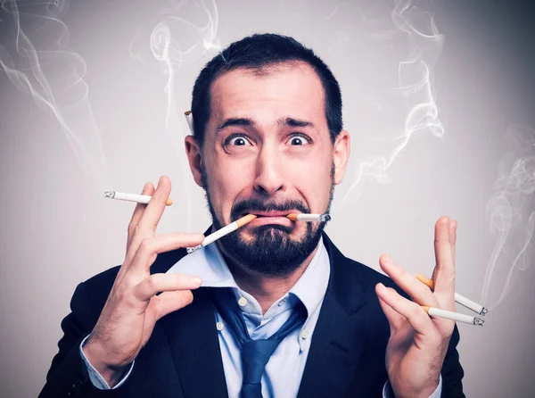 Businessman smoking many cigarettes at once — Stock Photo, Image