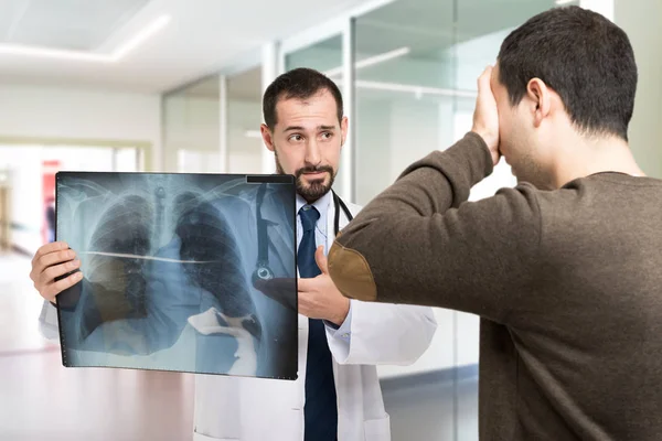 Läkare som visar en radiografi till patient — Stockfoto