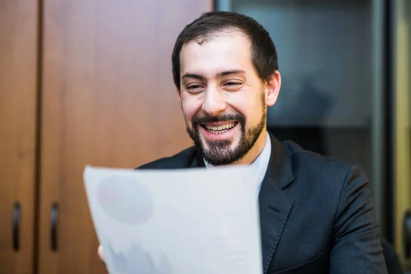 Lächelnder Geschäftsmann liest Dokument — Stockfoto