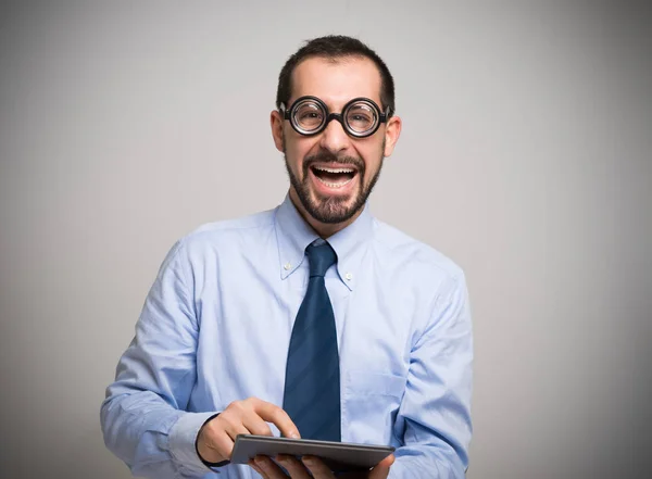 Lachende nerd met behulp van een tablet — Stockfoto