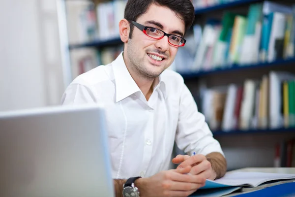 Mannen i glasögon leende i biblioteket — Stockfoto