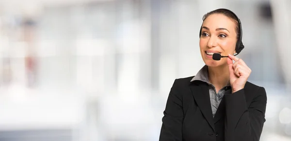 Affärskvinna talar via ett headset — Stockfoto