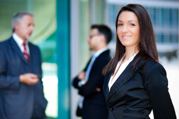 Businesswoman in front of her colleagues — Stock Photo, Image