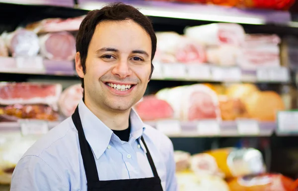 Tendero sonriente en la carnicería —  Fotos de Stock