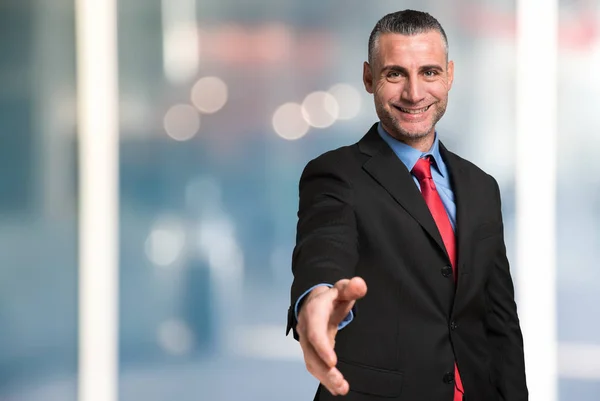 Businessman giving an handshake — Stock Photo, Image