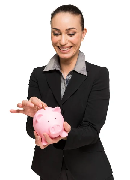 Mulher colocando dinheiro em seu banco porquinho — Fotografia de Stock