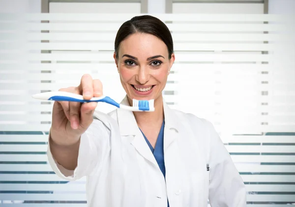 Стоматолог показывает зубную щетку — стоковое фото