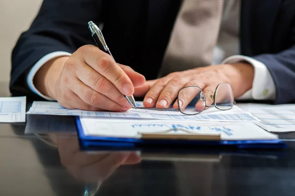 Geschäftsmann schreibt auf seine Agenda — Stockfoto