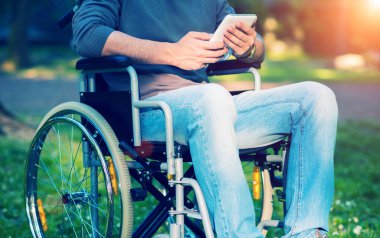 Bir tablet üzerinde tekerlekli sandalye kullanan adam