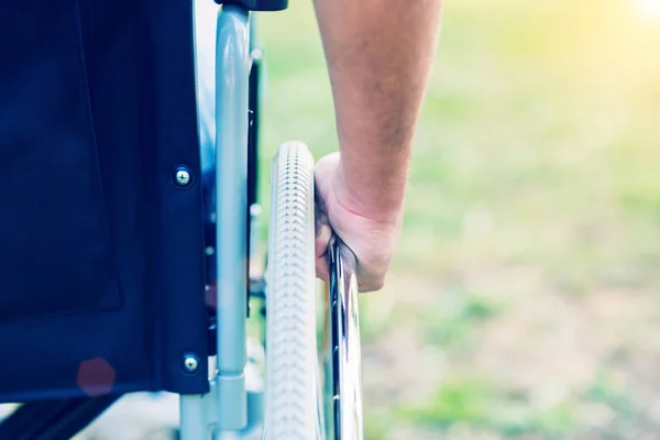 Человек толкает инвалидное кресло — стоковое фото