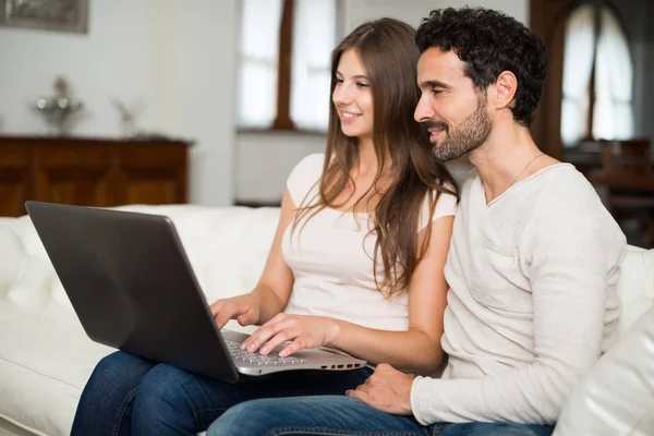 Pareja feliz usando un ordenador portátil —  Fotos de Stock