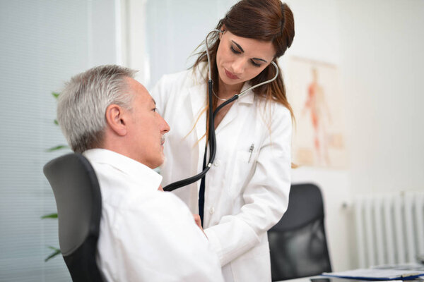 Doctor hearing a patient's heartbeat