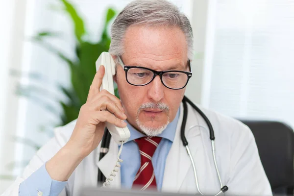 Senior doctor on phone — Stock Photo, Image