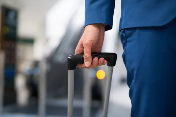 Empresario tirando de un carro en un aeropuerto — Foto de Stock