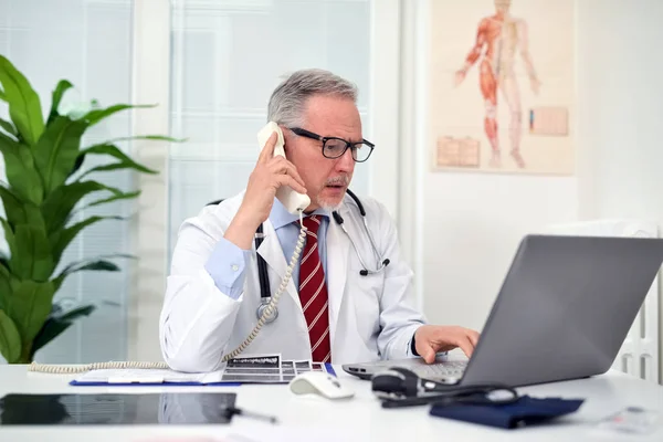 Médico falando ao telefone em estúdio — Fotografia de Stock