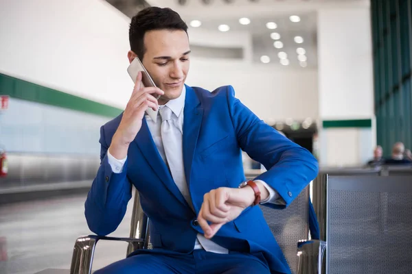 Reiziger tijd controleren en praten over de telefoon — Stockfoto