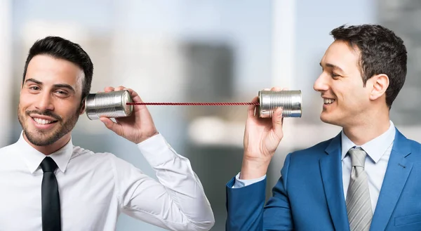 Men talking on tin can phone