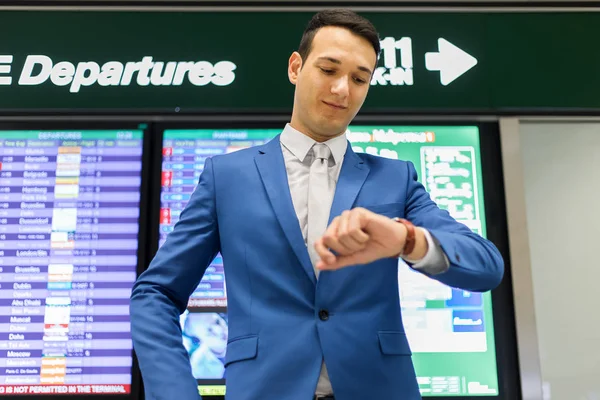 Empresário verificando o tempo no aeroporto — Fotografia de Stock