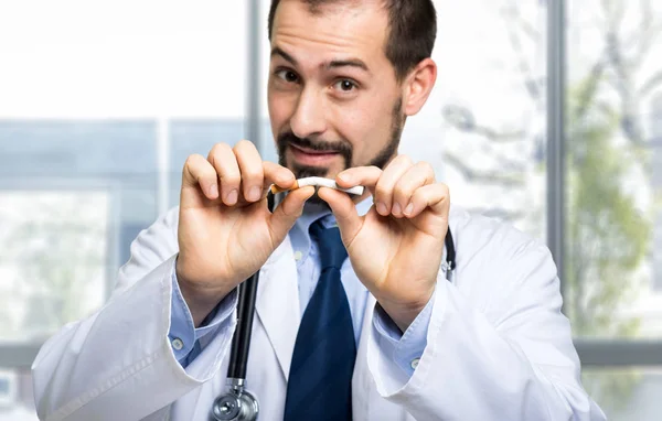 Handsome doctor breaking cigarette — Stock Photo, Image