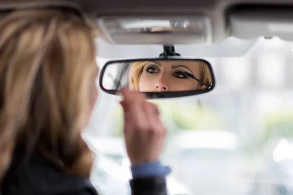 Mujer aplicando maquillaje en el coche —  Fotos de Stock