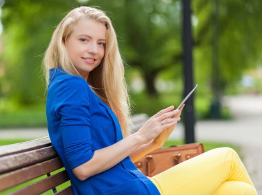 Tablet kullanan genç bir kadın.