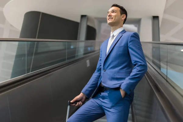 Бизнесмен держит тележку на эскалаторе — стоковое фото