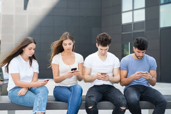 Amigos ignorándose entre sí debido a los teléfonos móviles — Foto de Stock