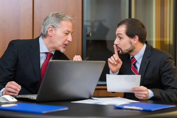 Businessman asking colleague to speak silently