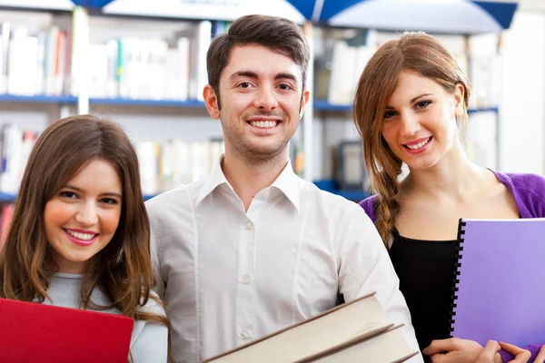 Studenten glimlachend in een bibliotheek — Stockfoto