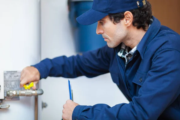 Loodgieter repareert een boiler — Stockfoto