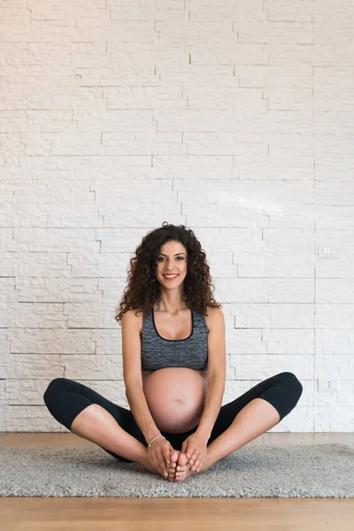 Mulher grávida fazendo alongamento — Fotografia de Stock