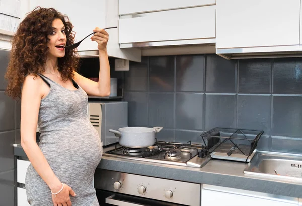 Pregnant woman cooking — Stock Photo, Image
