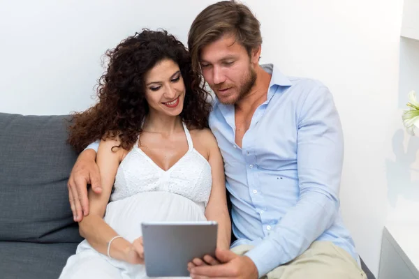 Zwangere vrouw en man met behulp van Tablet PC — Stockfoto