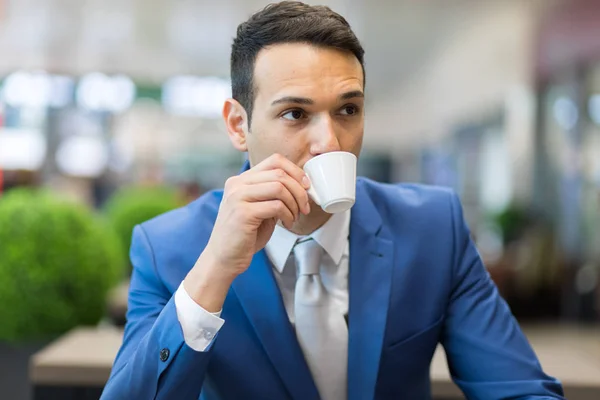 Affärsman som dricker kaffe på kafé — Stockfoto