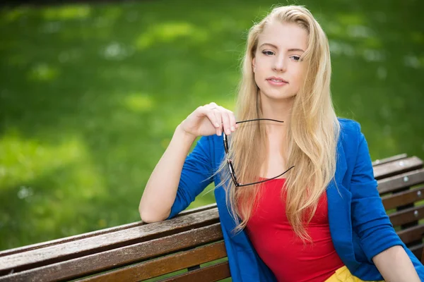 Frau entspannt sich auf einer Bank — Stockfoto