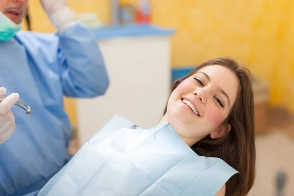 Dentista fazendo tratamento odontológico no paciente — Fotografia de Stock