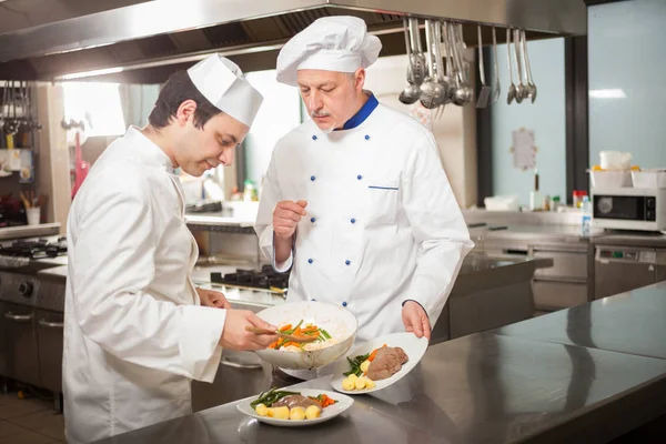 Chefs preparando prato em uma cozinha — Fotografia de Stock