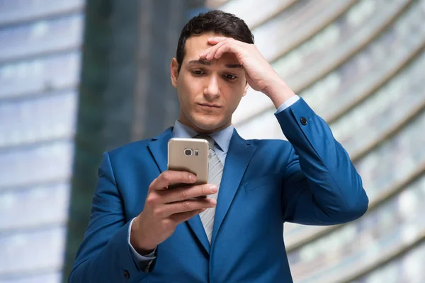 Trauriger Geschäftsmann schaut aufs Telefon — Stockfoto