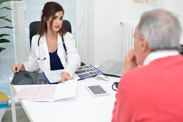 Läkaren talar till hennes patient — Stockfoto