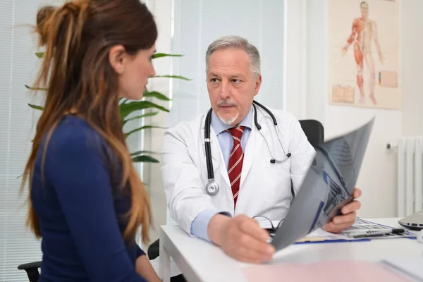 Doctor hablando de radiografía con paciente — Foto de Stock