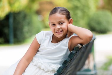 Bankta oturan çocuk gülümseyen 