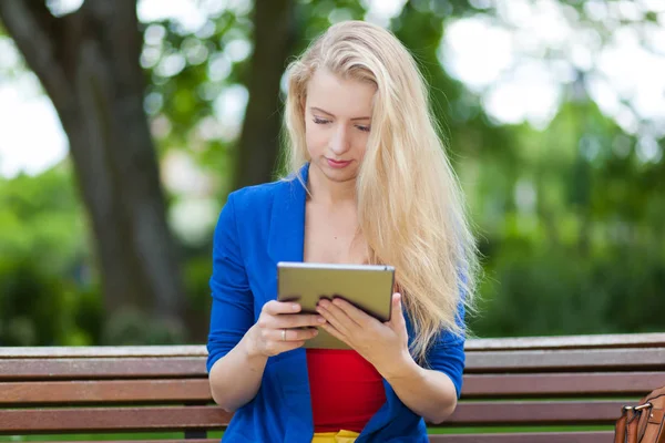 Frau benutzt Tablet im Park — Stockfoto