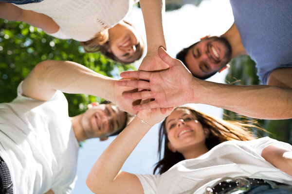 Друзья кладут руки вместе