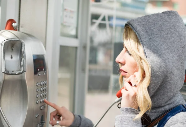 Woman dialing a payphone — Stock Photo, Image