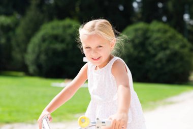 Gülümseyen güzel çocuk üzerinde bisiklet sürme