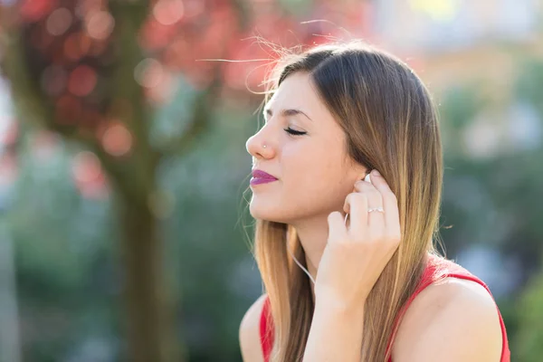 公園で音楽を聴いている若い女性 — ストック写真