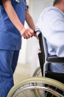 Doktor bir tekerlekli sandalye üzerinde bir hasta bakımı